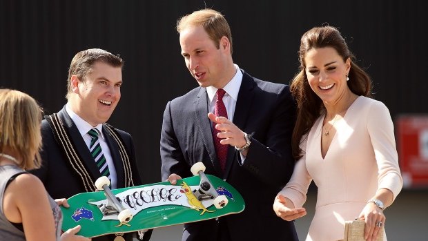 City of Playford Mayor, Mr Glenn Docherty, presents a skateboard to Prince William and Catherine at a skate park in Elizabeth on Wednesday.
