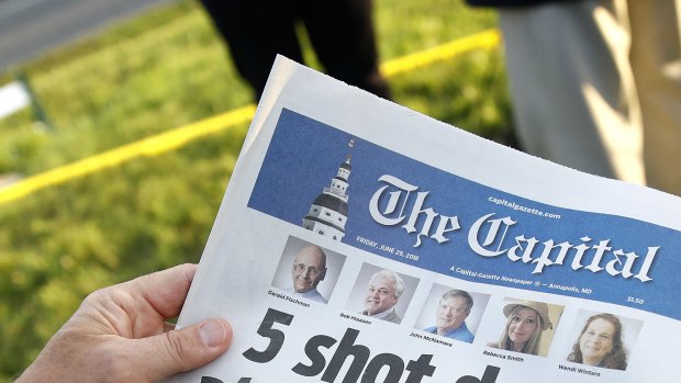 A reader holding a copy of The Capital a day after the shooting.