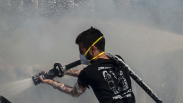 Israeli firefighters extinguish tractor tires in a farmland set on fire by a kite with attached burning cloth launched from Gaza on the Israeli side of the border, Tuesday, May 15, 2018. Israel faced a growing backlash Tuesday and new charges of using excessive force, a day after Israeli troops firing from across a border fence killed dozens of Palestinians and wounded more than 2,700 at a mass protest in Gaza. (AP Photo/Tsafrir Abayov)