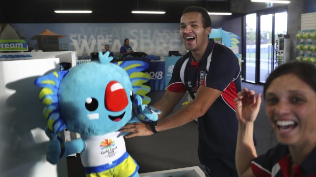 Athletes from the Falkland Islands play with Commonwealth Games mascot Borobi in the Games village.