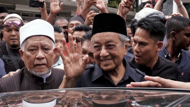 Malaysian Prime Minister Mahathir Mohamad, centre, waves to crowds leaving National Mosque after performing Friday prayers in Kuala Lumpur.