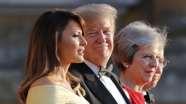President Donald Trump, second from the right, smiles as he listens to first lady Melania Trump, far left, speak as they stand with British Prime Minister Theresa May at Blenheim Palace.