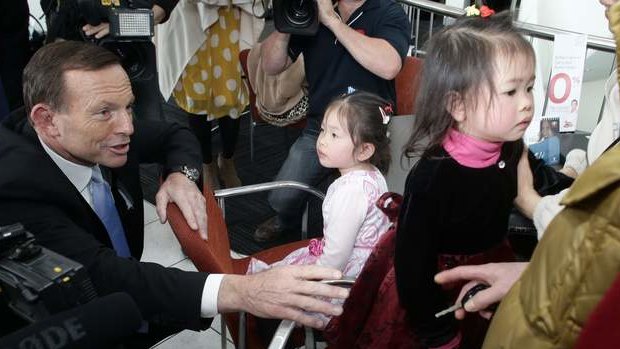 Opposition leader Tony Abbott meets with children at a Nunawading car  dealership in Victoria on Friday.