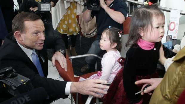 Opposition leader Tony Abbott meets with children at a Nunawading car  dealership in Victoria on Friday.