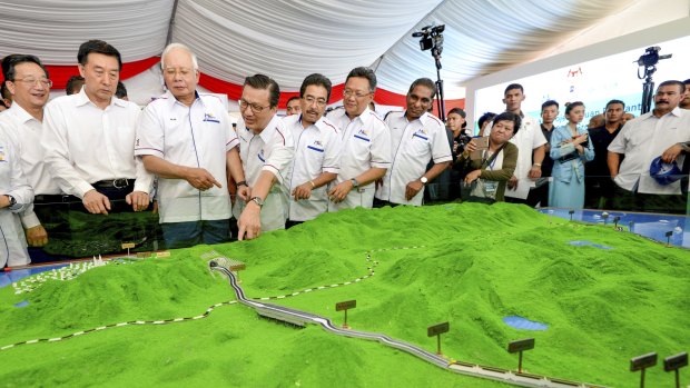 Former Malaysian prime minster Najib Razak, third from left, looks at models of the East Coast Rail Link.