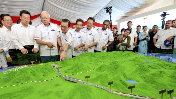 Former Malaysian prime minster Najib Razak, third from left, looks at models of the East Coast Rail Link.