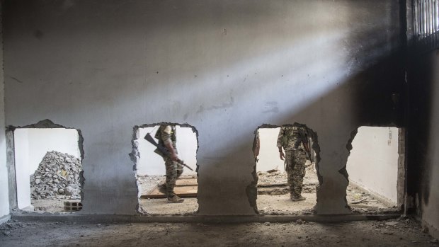 Members of the Syrian Democratic Forces (SDF) walk inside the stadium that was the site of Islamic State fighters' last stand in the city of Raqqa in October. 