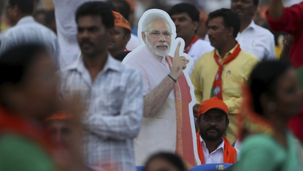 A cut-out of Indian Prime Minister Narendra Modi stands amidst the crowd during an election campaign rally in Bangalore.
