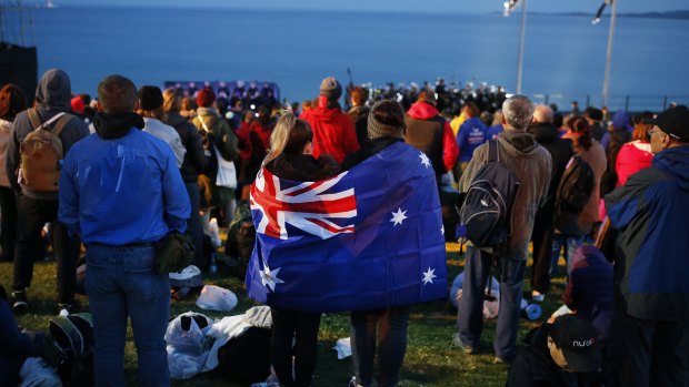 A pair draped with an Australian flag, participate in the Dawn Service ceremony at the Anzac Cove beach in Gallipoli, Turkey. 