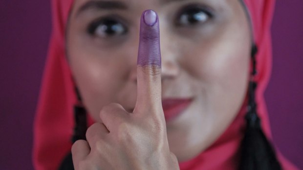 A Malaysian woman shows her inked finger after casting her ballot during the voting day of general elections on Wednesday.