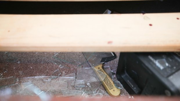 Shattered glass and large knife can be seen inside the gunman's unit on Friday morning. 
