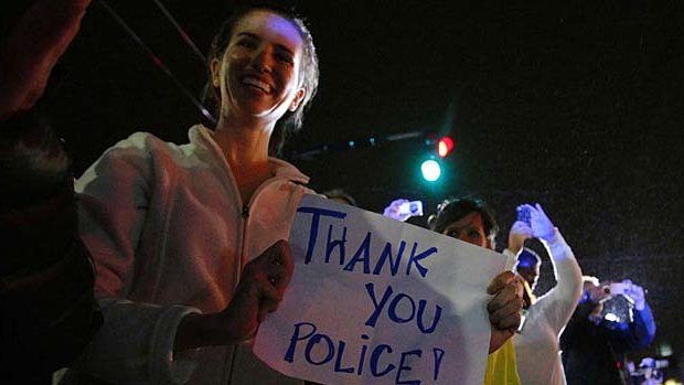 Members of the public cheer as police officers leave the scene where Dzhokhar Tsarnaev.