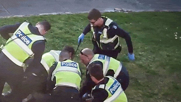 An image from CCTV showing police pinning pensioner John to the ground.