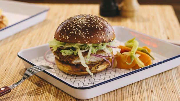 Panko-crumbed flounder burger with red onion, lettuce and lime aioli in a brioche bun.