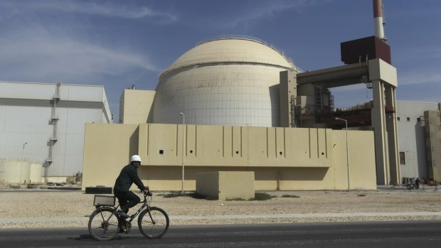 A worker rides a bike in front of the reactor building of the Bushehr nuclear power plant, just outside the southern city of Bushehr, Iran. 