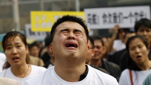 No end to the grief: A family member of a passenger on board Malaysia Airlines MH370 cries as he shouts slogans during a protest in front of the Malaysian embassy in Beijing.