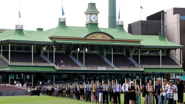 Tribute: Crowds observe 63 bats featuring images from Phillip Hughes' career prior to the memorial service for the former NSW and Test batsman in November.