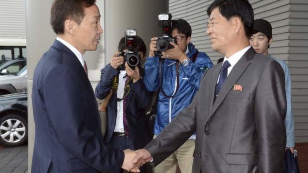 Head of the South Korean working-level delegation Kim Ki-woong, left, shakes hands with his North Korean counterpart Park Chol-su.