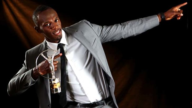 Usain Bolt strikes his trademark pose after receiving his award.