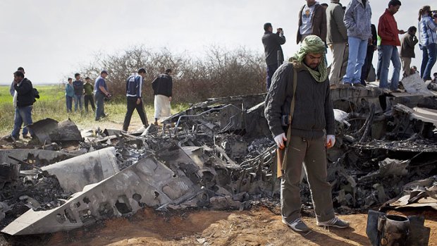 Locals look at a U.S Air Force F-15E fighter jet after it crashed near the eastern city of Benghazi.
