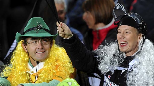 An All Blacks fan celebrates as dejected Australian looks on.
