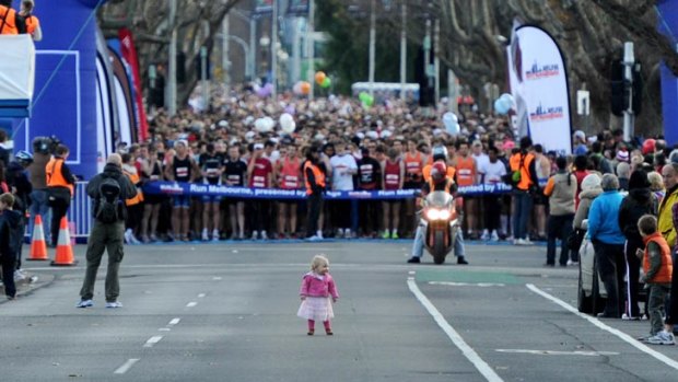 A tiny head start? It seems only fair... A toddler becomes an unofficial grid girl just before the start of Run Melbourne.