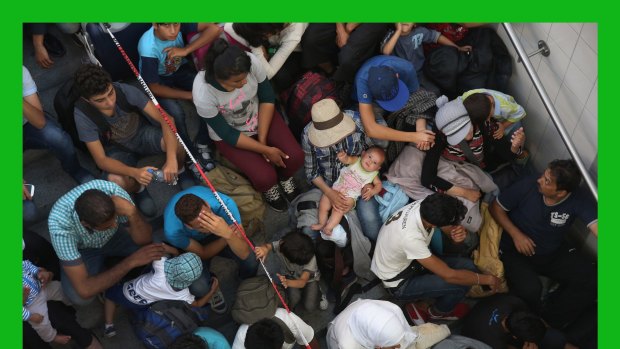 Migrants who arrived on a train from Budapest wait to be registered by the German police in Rosenheim.