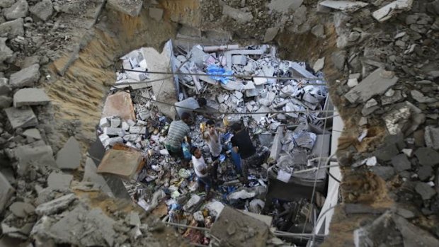 Palestinians search through the rubble of a destroyed building in Gaza.