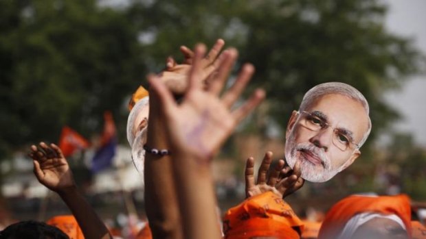 Supporters of the BJP hold up a mask of their prime ministerial candidate Narendra Modi.