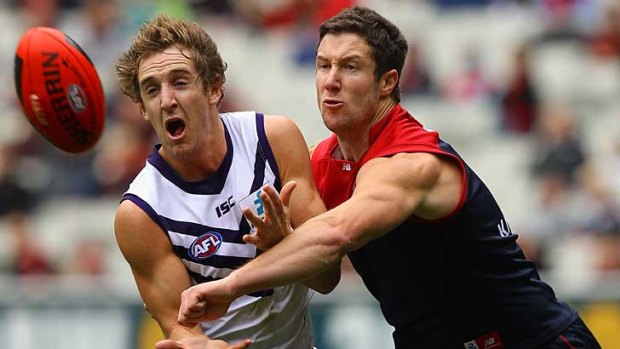 Fremantle's Michael Barlow and Melbourne's James Frawley battle for the ball at the MCG.