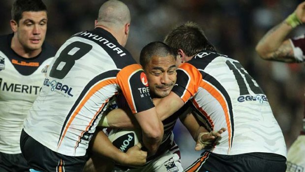 Tiger sandwich ... Manly's Joe Galuvao is tackled by Bryce Gibbs and Matt Groat.