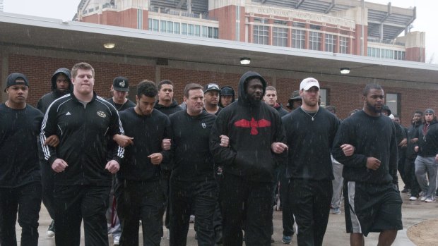 Training cancelled ... The University of Oklahoma football team and coaches line up wearing all black in the Everest Training Centre in protest of the Sigma Alpha Epsilon fraternity at the University of Oklahoma on Monday.