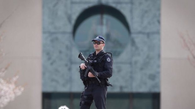 An AFP officer guards the perimeter of Parliament House as the government confirms a man shot dead in Melbourne was a ''known terror suspect''.