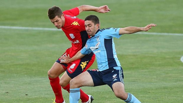 Dario Vidosic of Adelaide and Peter Triantis of Sydney each try to gain possession during the A-League game in Adelaide.