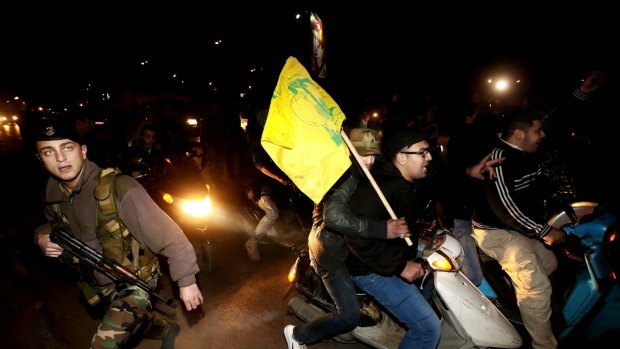 A Lebanese army soldier crosses a street past Hezbollah supporters at the Rafik Hariri International Airport in Beirut.