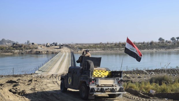 Iraqi forces cross a bridge over the Euphrates supplied by the US Army Corps of Engineers on the approach to Ramadi. Islamic State destroyed the existing bridges across the river as a defensive measure.