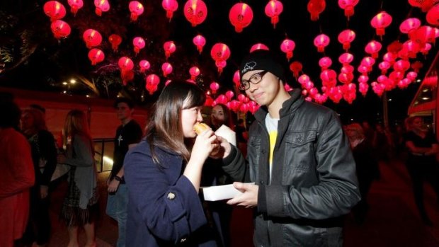 Sonia Zhuang and Pedro Tan are among thousands of people enjoy the food on offer at the Night Noodle Markets at the Cultural Forecourt, South Bank.