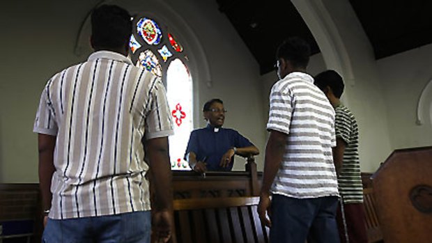 Adjusting to new lives ... Sri Lankan Tamil refugees speak to the Reverend John Jegasothy of the Dulwich Hill Uniting Church.