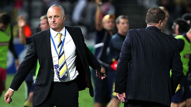 Mariners coach Graham Arnold with his Melbourne Victory counterpart Ange Postecoglou (back to camera) after the game.