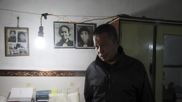 Gao Zhisheng walks past photos of his relatives in a cave home in north-western China's Shaanxi province in this photo taken earlier this year. 
