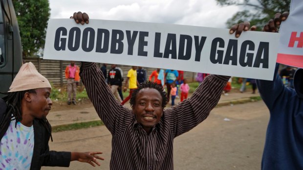 A protester demanding that President Robert Mugabe stands down carries a placard referring to Mugabe's wife Grace Mugabe, 