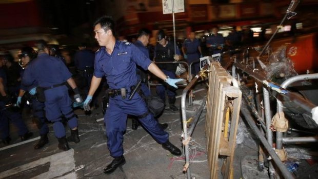 A policeman removes a barricade at a protest site at Mongkok.