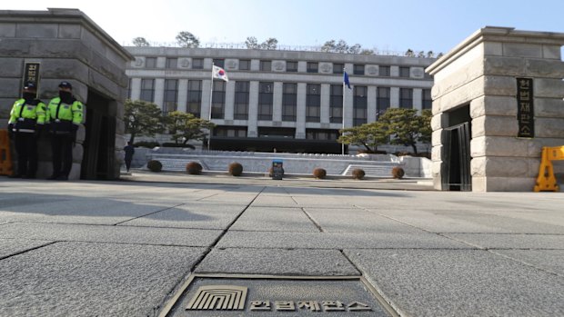 South Korean police officers stand in front of the Constitutional Court in Seoul, South Korea, on Tuesday.