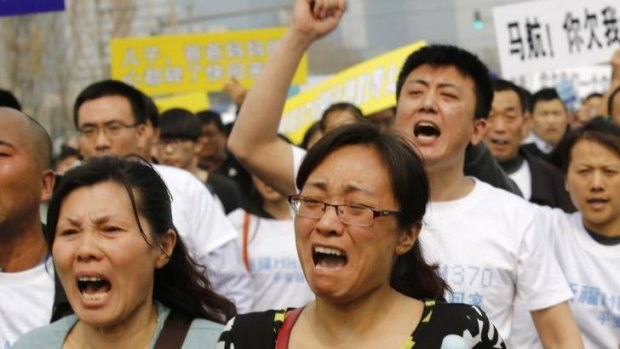 Distraught: Family members of passengers on board Malaysia Airlines MH370 shout slogans during a protest in front of the Malaysian embassy in Beijing.