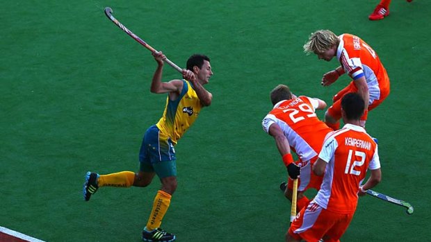 Whack: Australia’s Jamie Dwyer gets a shot away in the final against the Netherlands