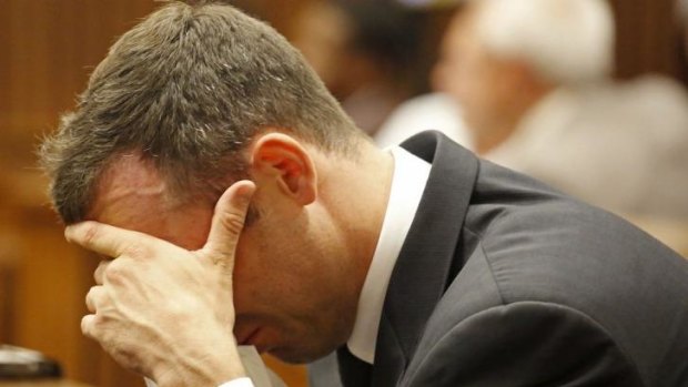 Reliving the moment ... Oscar Pistorius puts his hand to his face as he listens to cross examination of witnesses about the events surrounding the shooting death of his girlfriend Reeva Steenkamp on Valentine's Day, 2013.