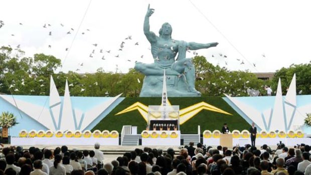 Doves fly around the Peace Statue of the Peace Memorial Park after being released in the Memorial Ceremony for atomic bomb victims in Nagasaki.