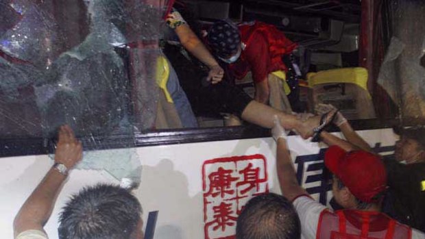 A hostage is carried out through the smashed window of the bus.