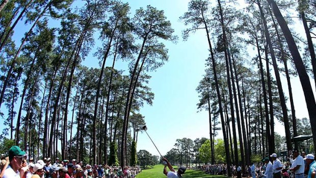 Adam Scott hits a tee shot in front of a gallery of patrons during a practice round at Augusta.