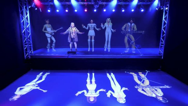 A visitor sings karaoke with giant holograms featuring members of Abba at the Abba Museum in Stockholm.